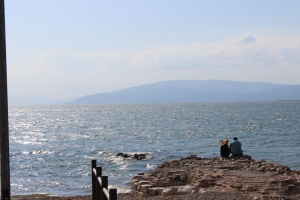 Cute couple sitting on the rocks at Iznik Lake. 
